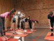 Fitness group performing exercises with dumbbells in a modern yoga studio setting.